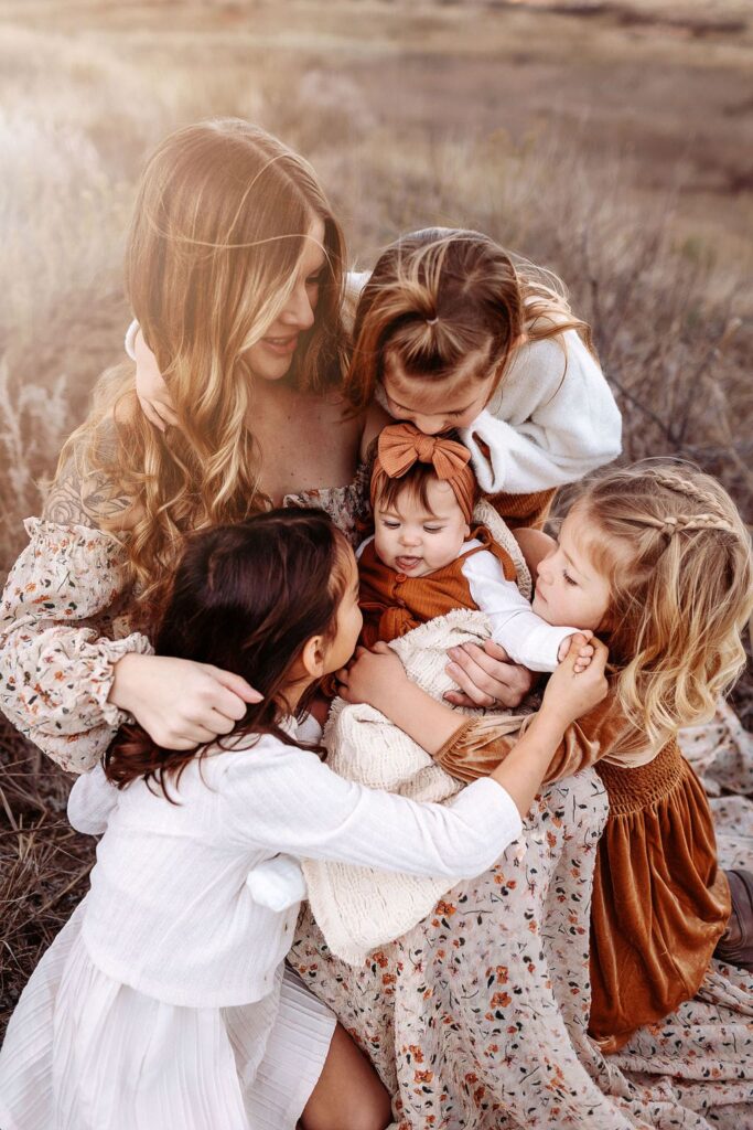 A joyful moment of siblings holding hands during a family photography Denver session in fall.