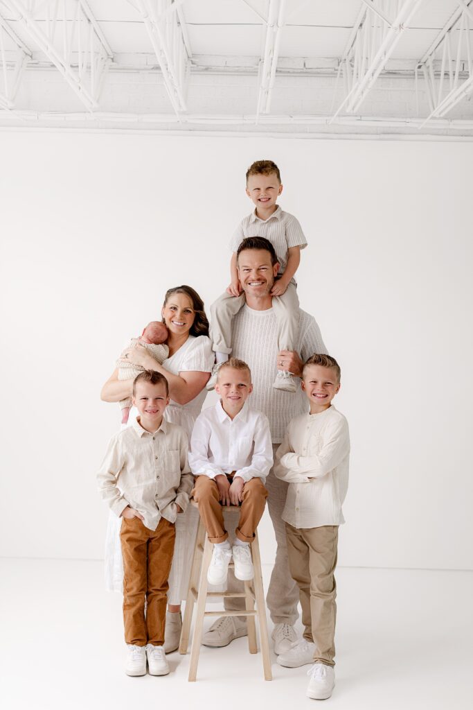 denver photographer poses family of 7 with their new puppy in a cute in a fun candid pose during their studio photoshoot