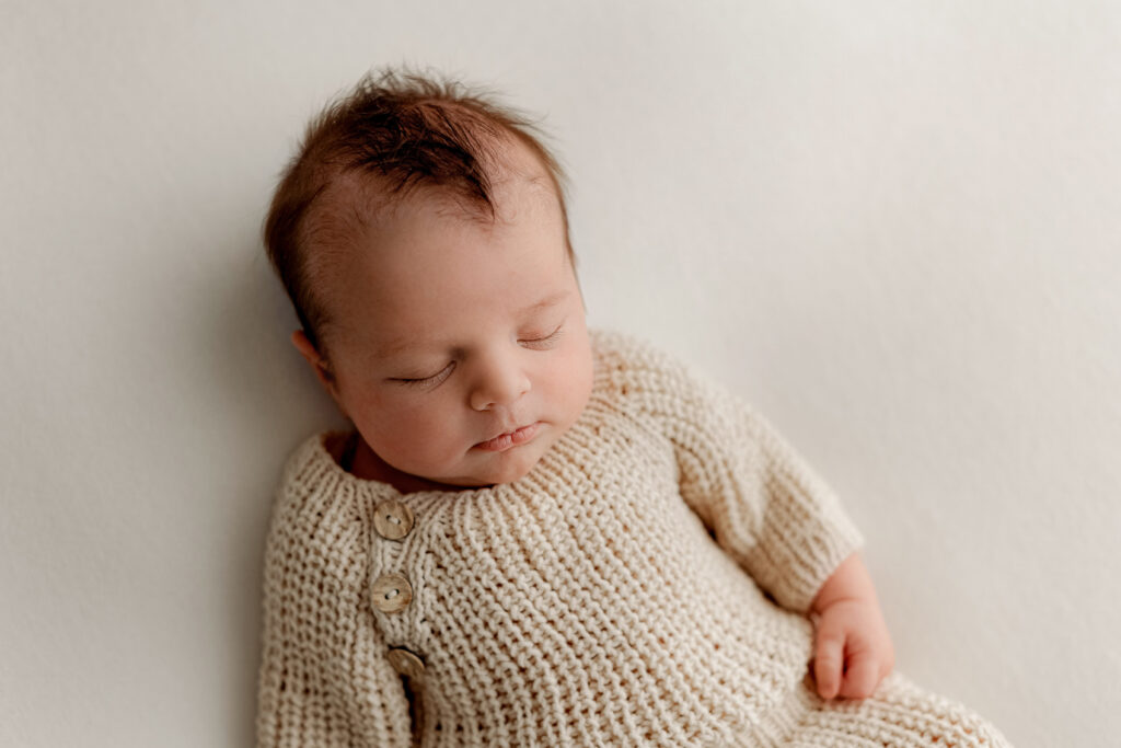 fort collins photographer dresses newborn baby in adorable knit romper for natural newborn photo session