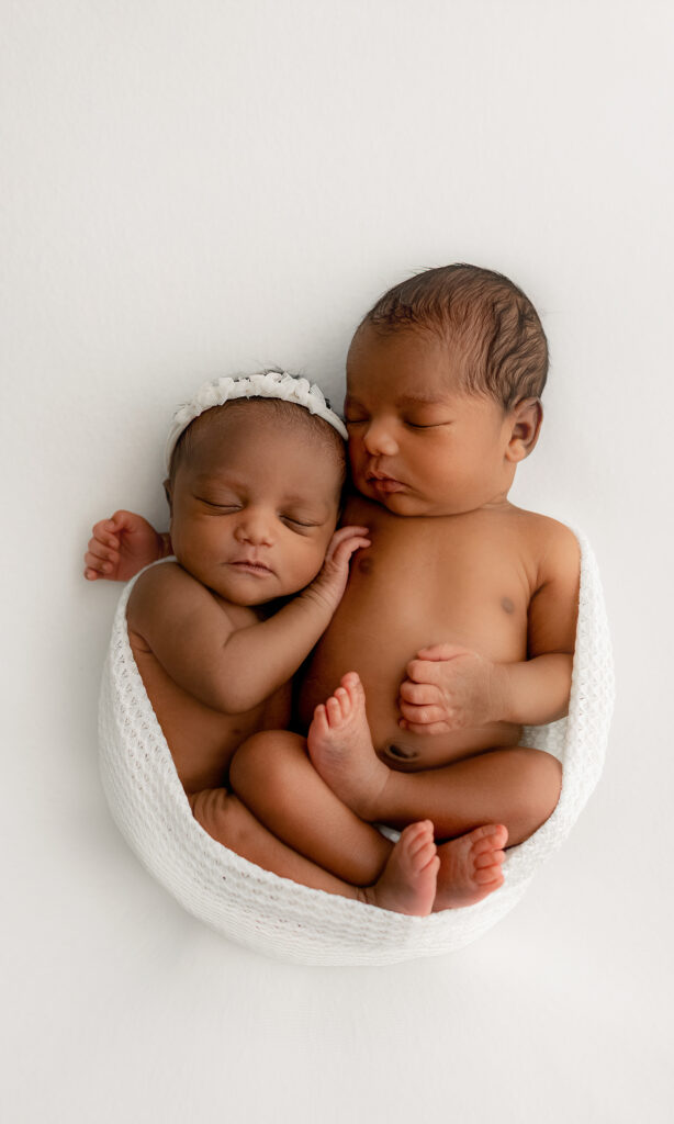 award winning newborn photographer poses boy and girl twins at 5 days old in her all white studio space