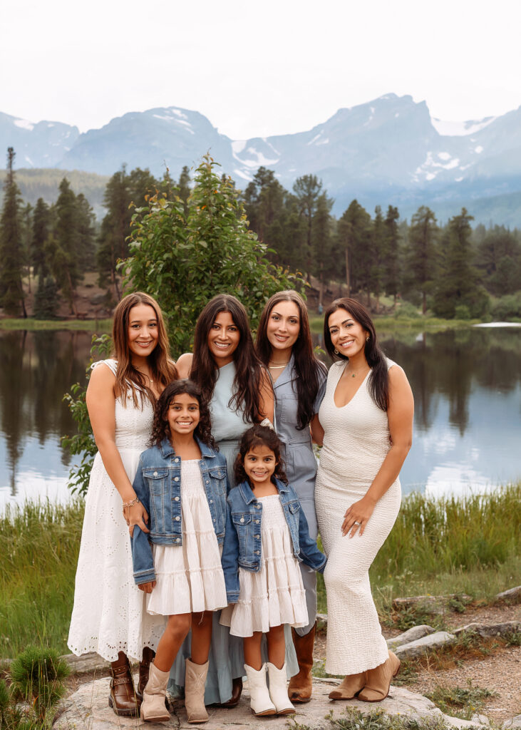 Family cuddled together among golden aspen trees during a fall photo session in Estes Park, Colorado.