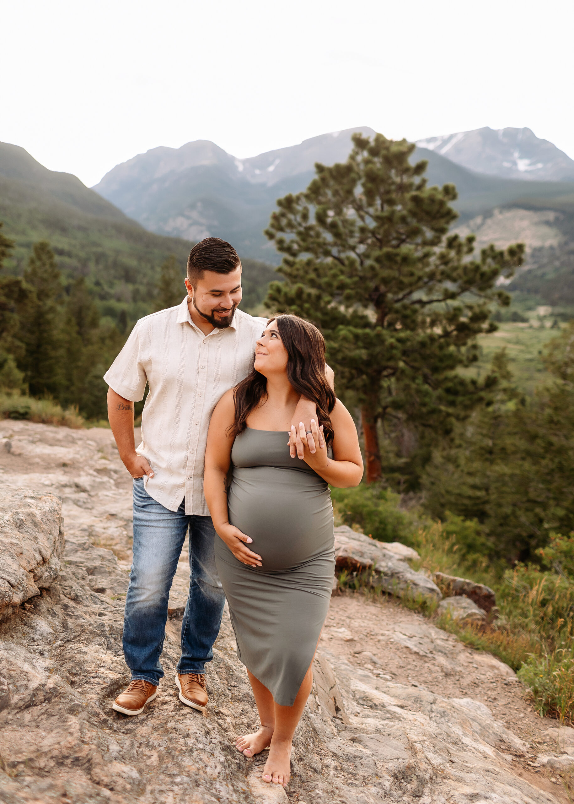 Pregnant woman standing in Rocky Mountain National Park with dramatic mountain views, captured by an Estes Park maternity photographer.