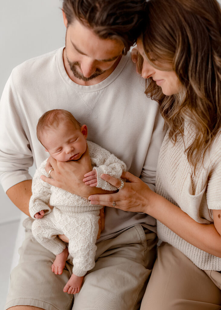 parents wearing neutral outfits for newborn photos in denver studio