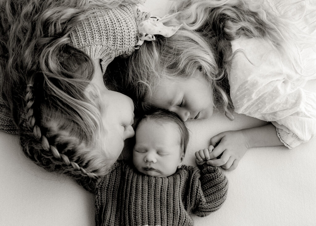 Denver newborn photographer captures a baby boy wrapped in a soft cream blanket during a studio session.