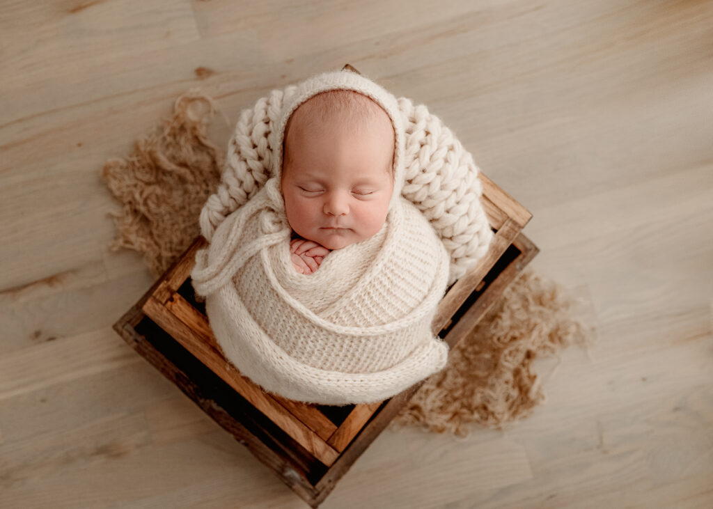 Studio newborn photography session with soft light and neutral tones