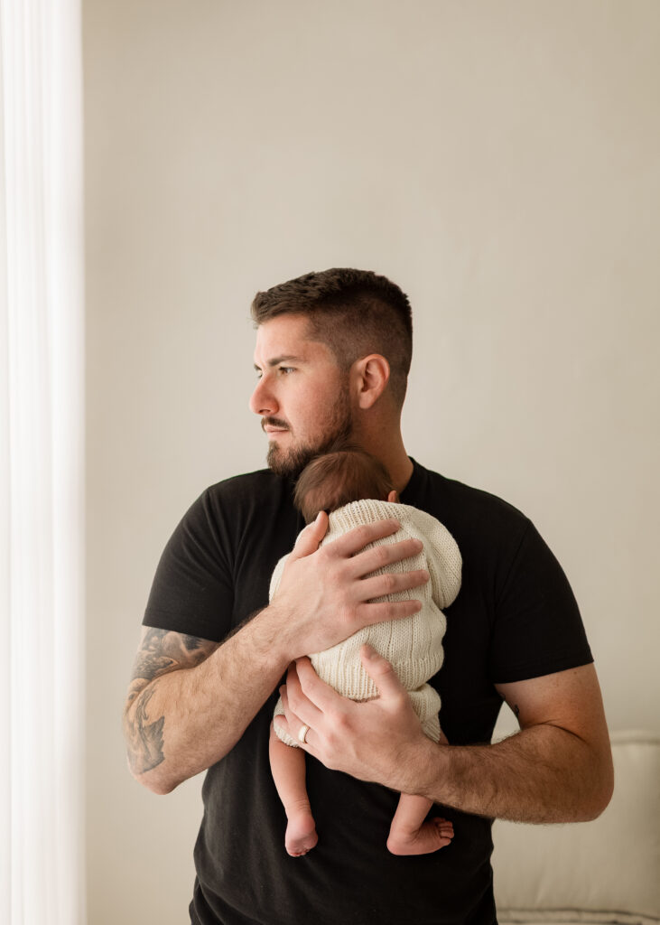 newborn baby held by parent during soft natural studio photography session
