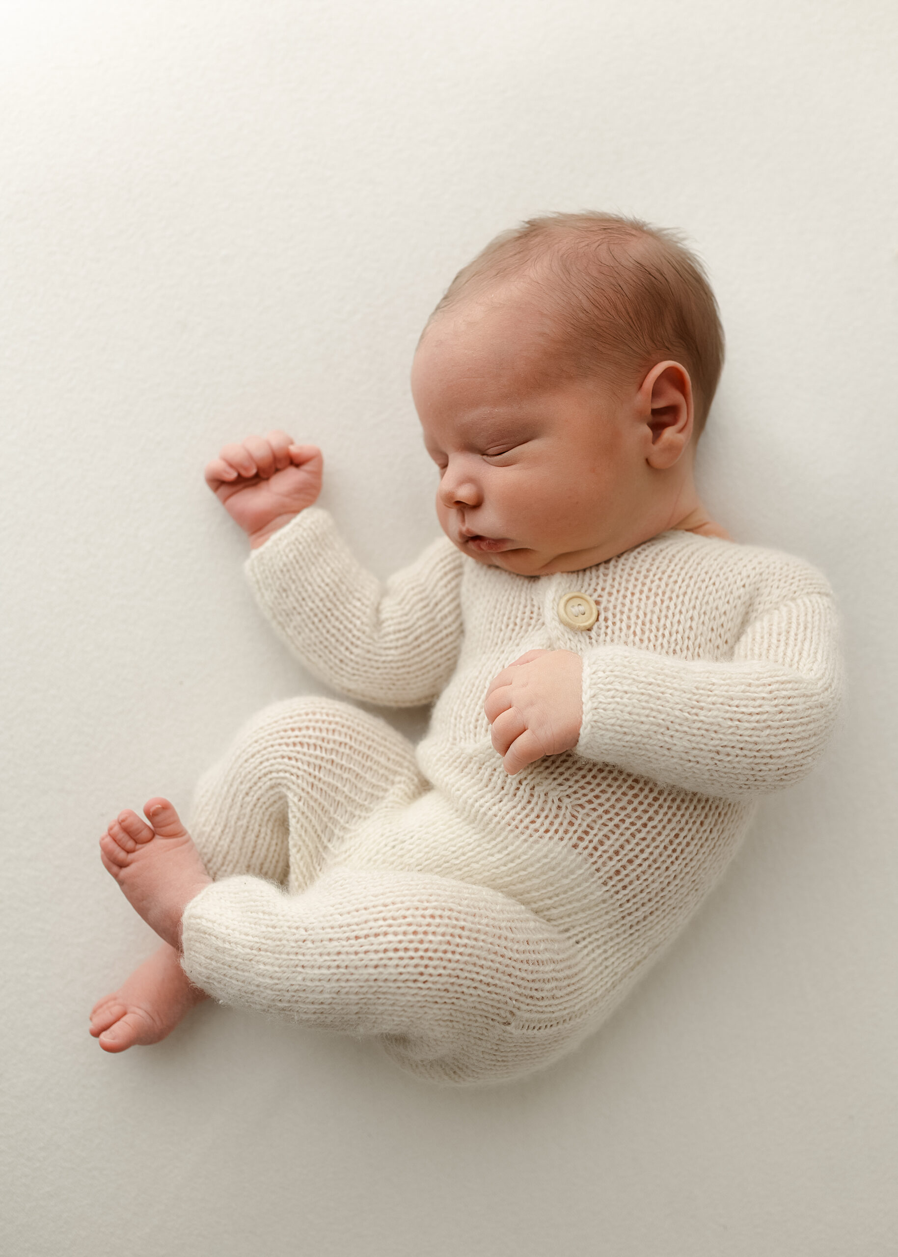 Denver newborn photographer studio session with soft neutral tones and wrapped baby